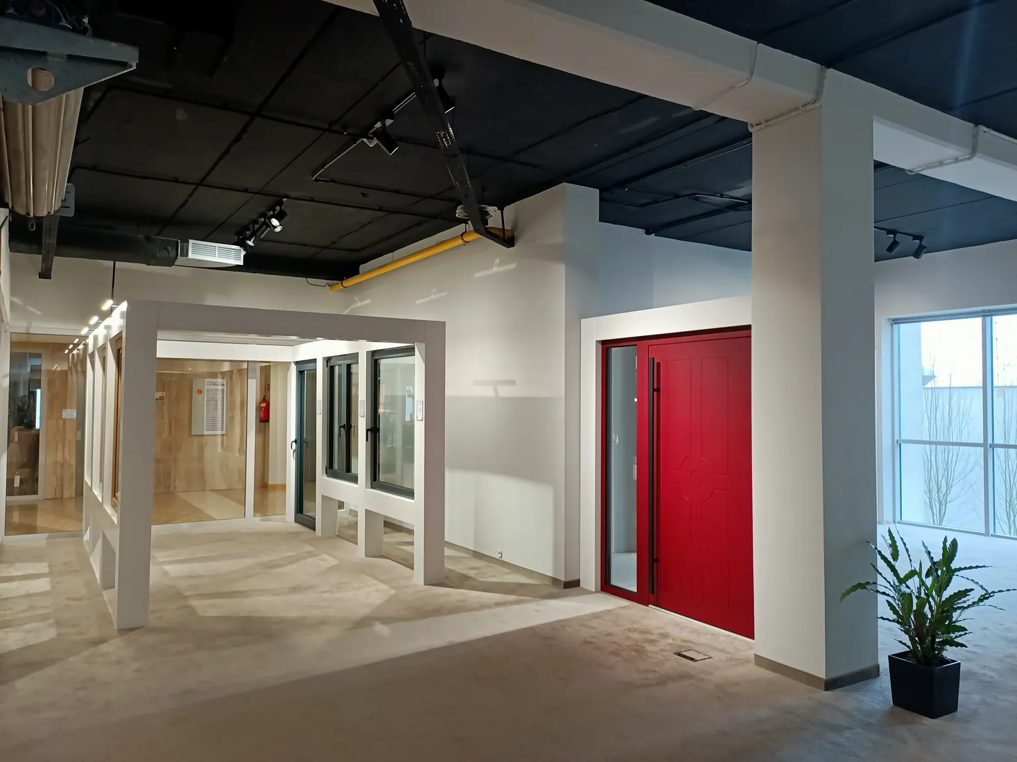 Czerwone drzwi zewnętrzne i aleja okien — Salon BUDVAR Poznań – Galeria Arkada
