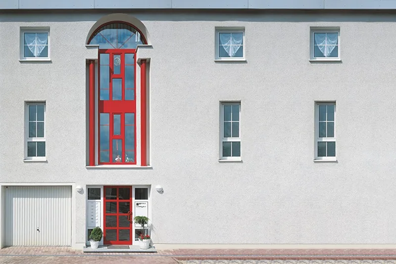 Okna PCV wyposażone w nakładki aluminiowe w budynku